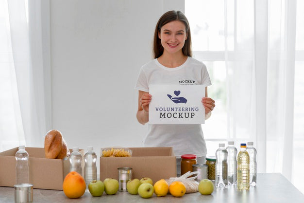 Smiley Female Volunteer Holding Blank Page While Preparing Food For Donation Psd