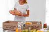 Smiley Female Volunteer Preparing Food In Box For Donation Psd