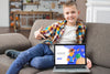 Smiley Kid On Couch Pointing At Laptop Psd