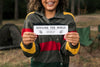 Smiley Woman Holding A Piece Of Paper While Camping Psd