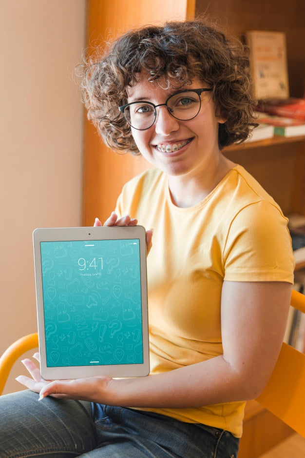 Smiling Woman Holding Tablet Mockup In Library Psd