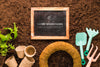 Top View Of Blackboard On Soil With Plants And Tools Psd