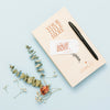 Top View Of Book Mock-Up With Pen And Flowers Psd