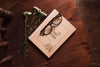 Top View Of Book On Chair With Flowers And Glasses Psd
