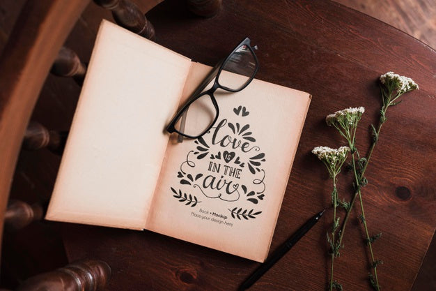 Top View Of Book With Glasses And Flowers In Chair Psd