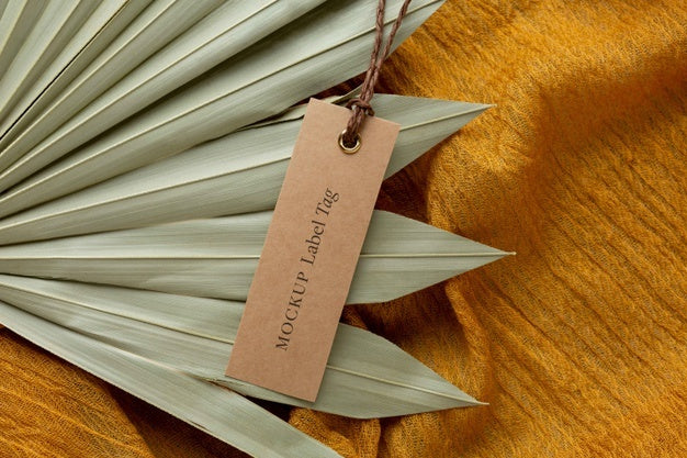 Top View Of Clothing Label Mock-Up On Orange Textile With Leaves Psd