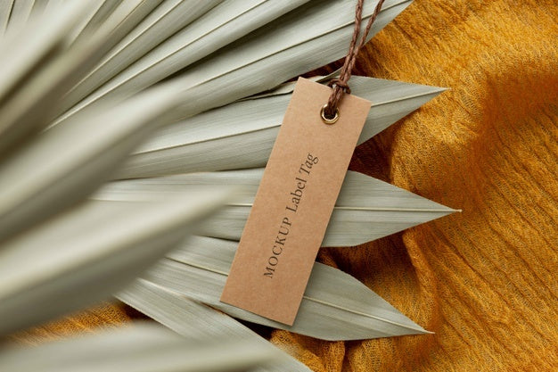 Top View Of Clothing Label Mock-Up On Orange Textile With Leaves Psd