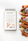 Top View Of Fish With Shrimp And Notebook Psd