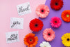 Top View Of Flowers And Letters On Pink And Purple Background Psd