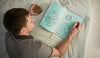 Top View Of Man Writing In Notebook On Bed Psd