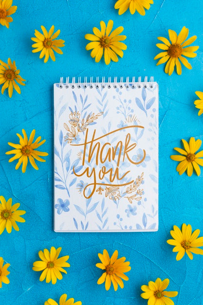 Top View Of Notebook And Flowers On Blue Background Psd