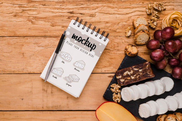 Top View Of Notebook With Variety Of Cheese And Grapes Psd