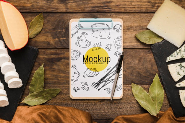 Top View Of Notepad With Pen And Variety Of Cheese Psd