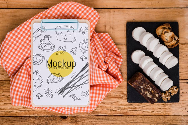 Top View Of Notepad With Tablecloth And Variety Of Cheese Psd