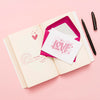 Top View Of Open Book With Envelope And Card Psd