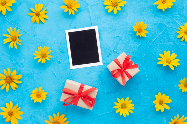 Top View Of Photo And Gifts With Yellow Chamomile Psd