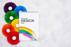 Top View Of Rainbow Colored Rosettes And Notebook Psd
