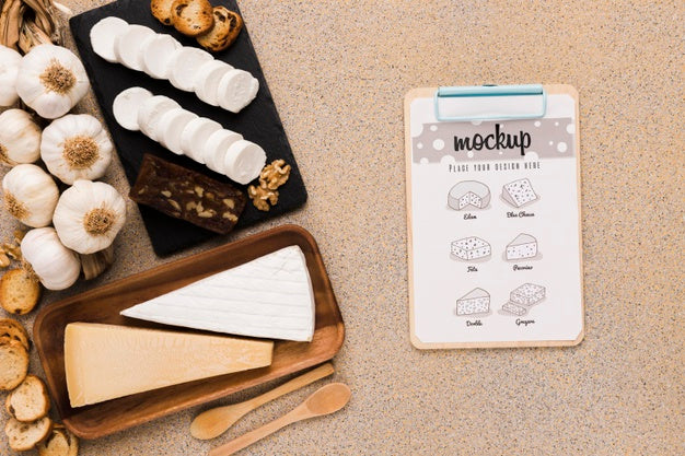 Top View Of Variety Of Cheese With Spoons And Notepad Psd
