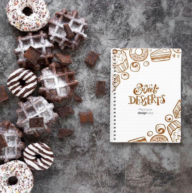 Top View Of Waffles And Donuts With Notebook Psd