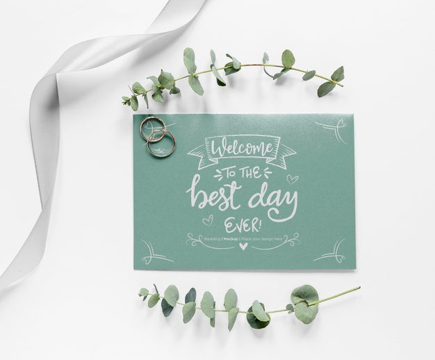 Top View Of Wedding Card With Plants And Rings Psd