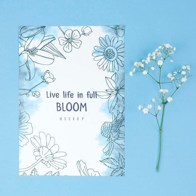 White Flower Placed Next To Card Mockup Psd