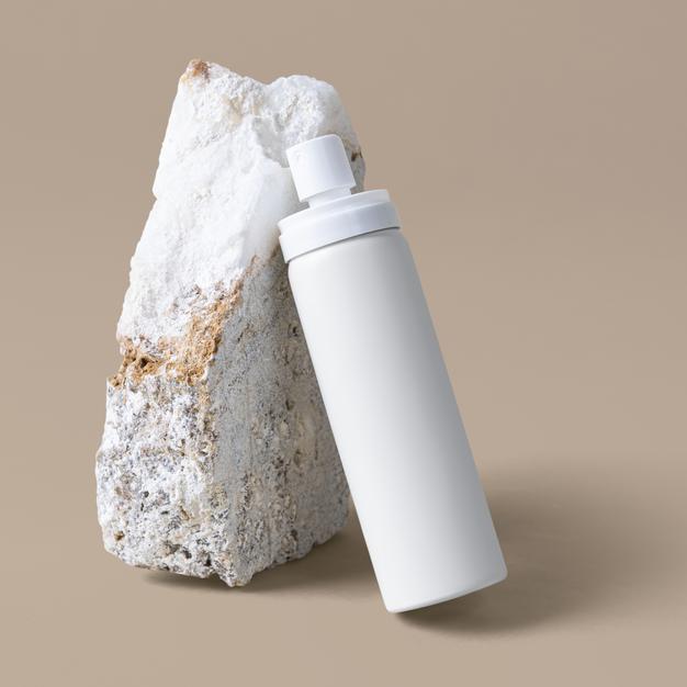 White Spray Bottle Mockup Against A Rock Psd
