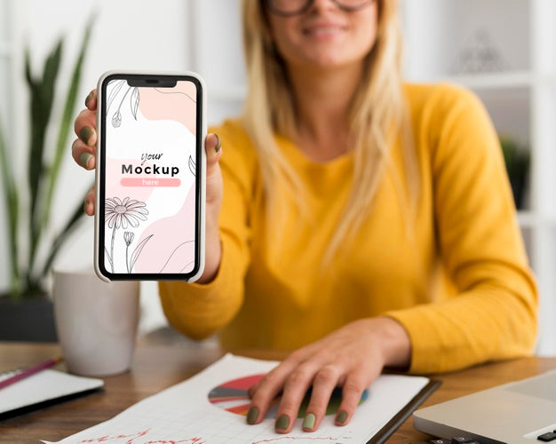 Woman At Desk Showing Phone Mock-Up Psd