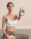 Woman Doing Yoga And Holding Smartphone Psd