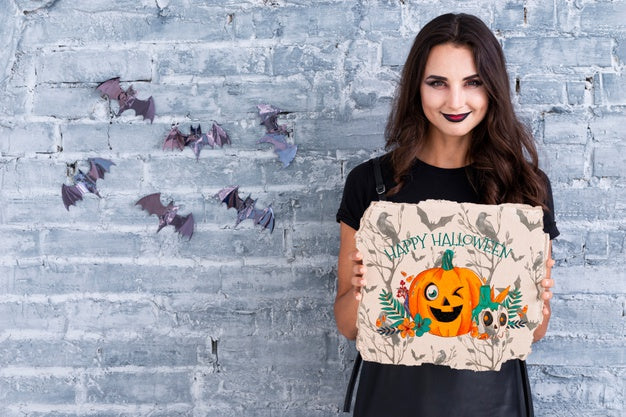 Woman Holding A Card With Carved Pumpkin For Halloween Psd