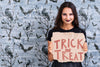Woman Holding A Card With Trick Or Treat Lettering Psd