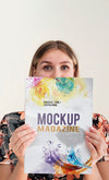 Woman Holding A Mock Up Magazine And Looking At Camera Psd