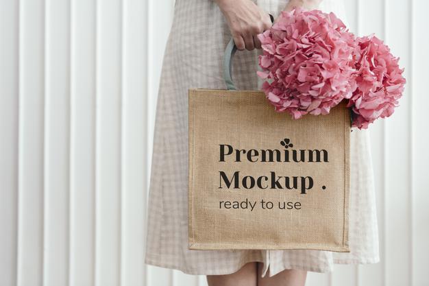 Woman Holding A Woven Tote Bag Mockup With Pink Hydrangea Flowers Psd