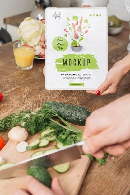 Woman Holding Book In The Kitchen While Man Cooks Psd