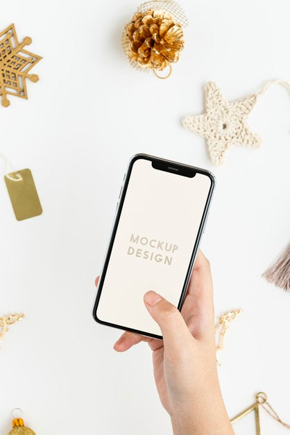 Woman Holding Her Phone Above Gold Christmas Ornaments Mockup Psd