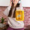 Woman Holding Orange Juice Jar While Listening To Music On Headphones Psd