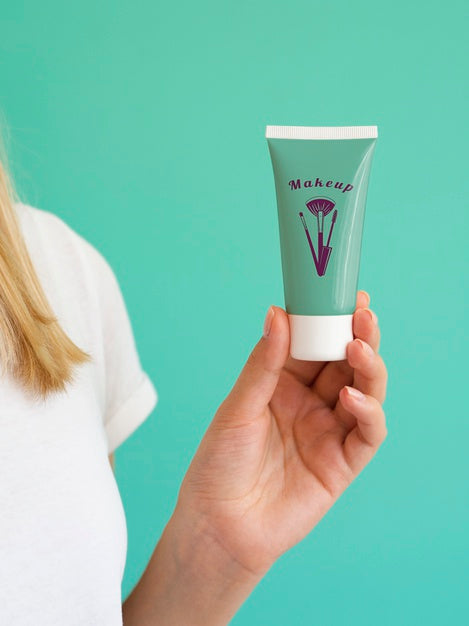 Woman Holding Up A Hand Cream Bottle Psd