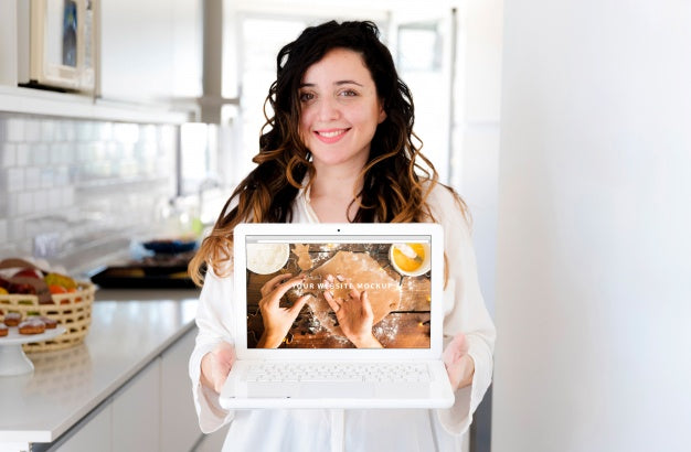 Woman In Kitchen Presenting Laptop Mockup Psd