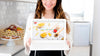 Woman In Kitchen Presenting Laptop Mockup Psd