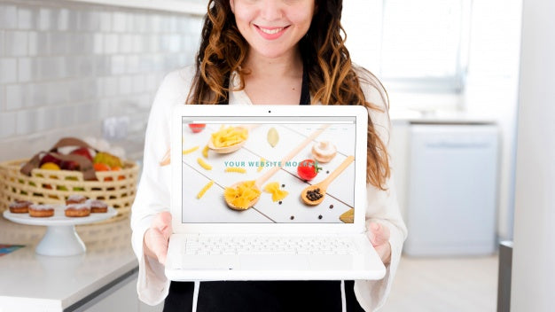 Woman In Kitchen Presenting Laptop Mockup Psd