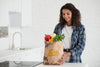 Woman In Kitchen With Bag Of Fresh Vegetables Psd