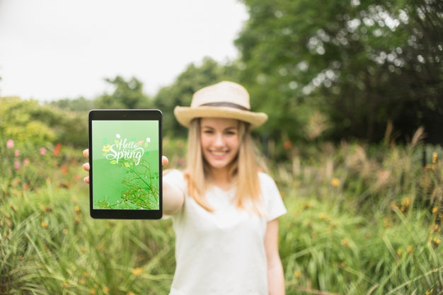 Woman Presenting Tablet Mockup In Nature Psd