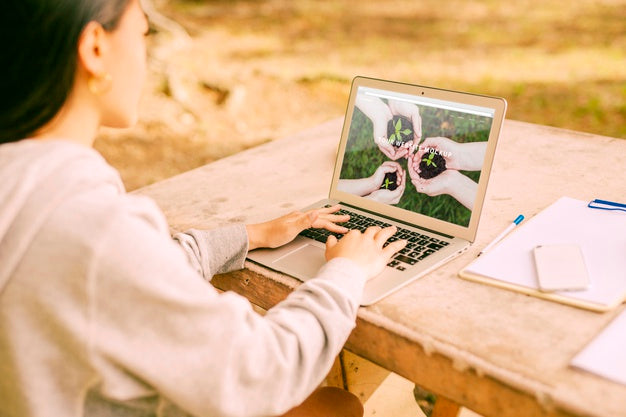 Woman Using Laptop Mockup In Nature Psd