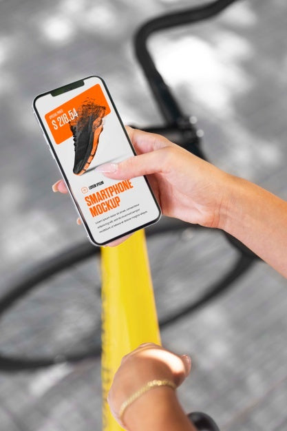 Woman Using Mock-Up Smartphone Outdoors While On Bicycle Psd