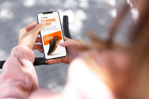 Woman Using Mock-Up Smartphone Outdoors While On Bicycle Psd