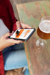 Woman Using Mock-Up Smartphone Outdoors With A Glass Of Drink Psd