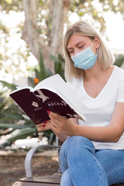 Woman Wearing Mask On Street Reading Book Psd