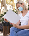Woman With Mask On Street Reading Book Psd