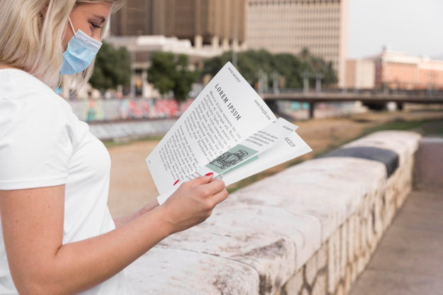 Woman With Mask Reading Book On Street Psd