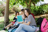 Women Looking At Tablet Mockup In Park Psd