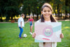 Young Girl In Park Holding Sign With Positive Message Psd